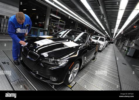 An employee of BMW works on a new 3 series car at the BMW plant in ...