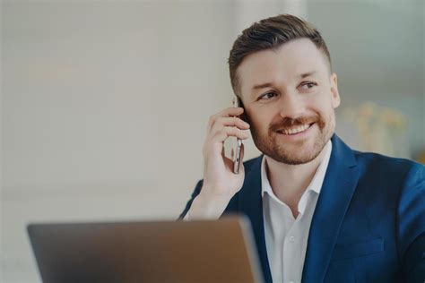 Happy Young Handsome Businessman Talking On Mobile Phone With Partner