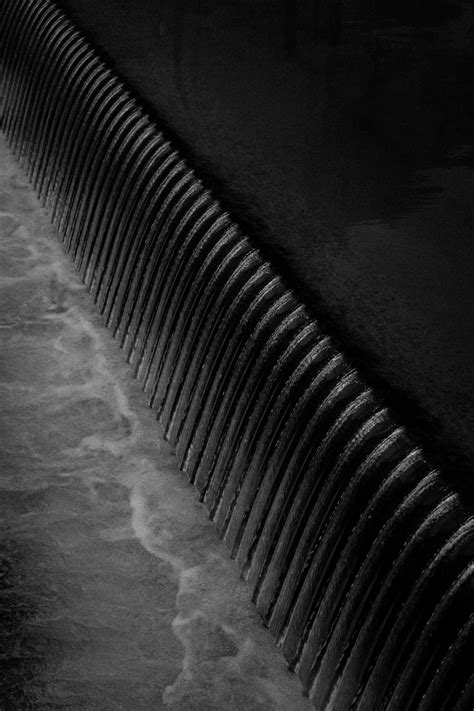 Une Photo En Noir Et Blanc De Leau Qui Coule Sur Un Mur Photo Photo