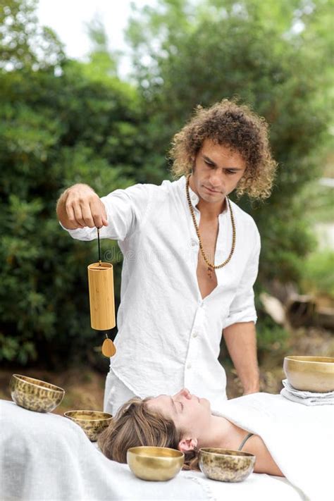 Long Hair Man Holding A Bamboo Koshi Chime During Sound Healing Therapy