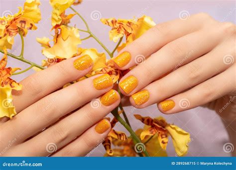 Female Hand With Yellow Nail Design Glitter Yellow Nail Polish