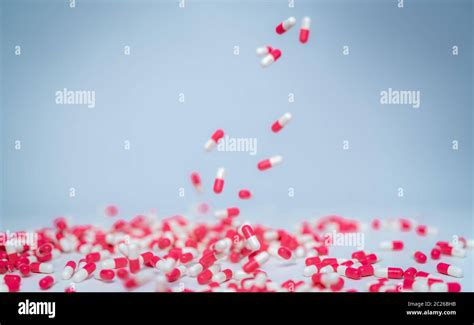 Selective Focus On Pink White Capsule Pill Fall Down To White Table