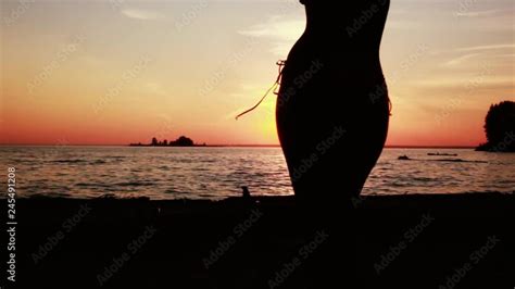 Silhouette of sexy girl in bikini dances on the beach at amazing sunset x Stock ビデオ