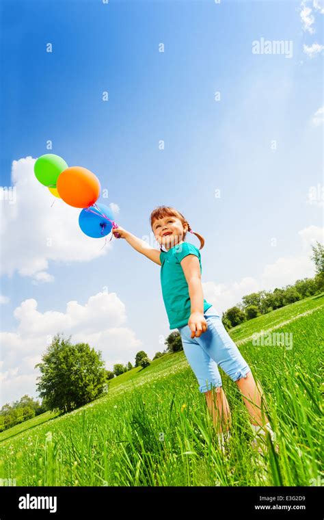 Small smiling girl with colorful balloons Stock Photo - Alamy