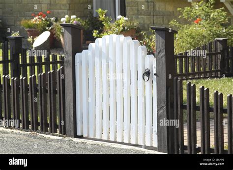 white wooden gate and low fence around a garden Stock Photo - Alamy