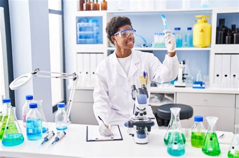 African American Woman Wearing Scientist Uniform Write On Clipboard