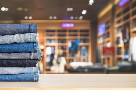 Los Jeans Azules Se Apilan En La Mesa De Madera Con Una Tienda De Ropa