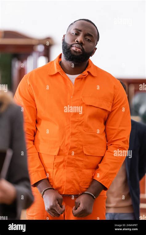 Handcuffed African American Man In Orange Jail Uniform In Courtroom On