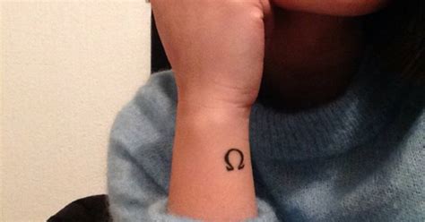 Wrist tattoo of the greek letter Omega on Kimberly.