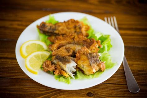 Fried Hake Fish In Batter With Lettuce And Lemon In A Plate Stock Photo