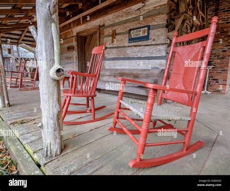 Old Fashioned White Rocking Chairs On The Front Porch Of An Old Cabin