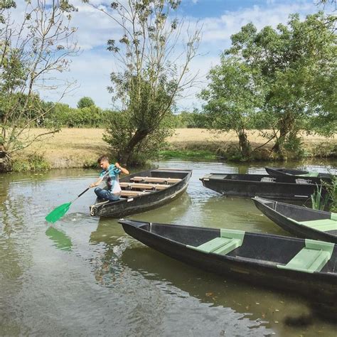 Two People In Canoes Paddling Down A River