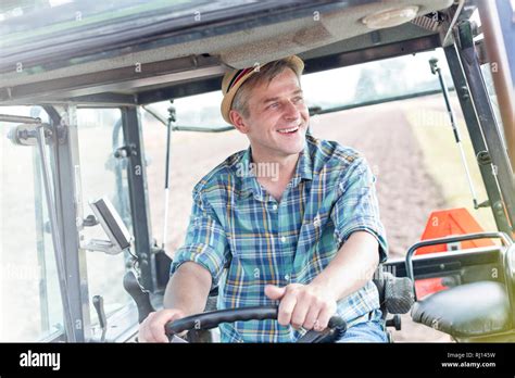 Smiling Confident Farmer Driving Tractor At Farm Stock Photo Alamy