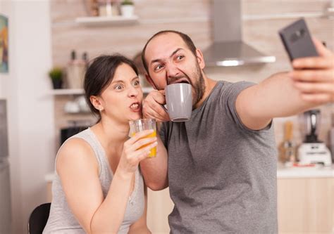 Amantes felices tomando selfies con el teléfono por la mañana bebiendo