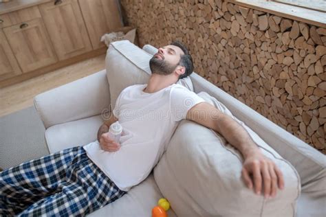 Young Happy Father Sleeping On The Sofa Feeling Exhausted Stock Image