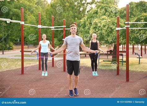 Group Of Sporty People Jumping Rope On Athletic Field Outdoors Stock