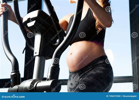 Pregnant Woman in Sports Workout Outfit Training on an Elliptical ...