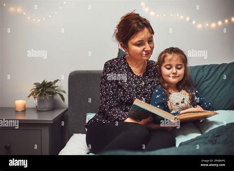 Mother Reading Book Her Daughter In Bed Before Going To Sleep Reading