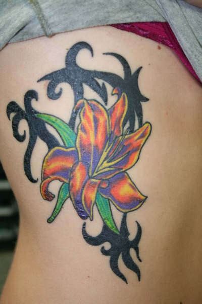 Orange lily with tribal tracery tattoo - Tattooimages.biz