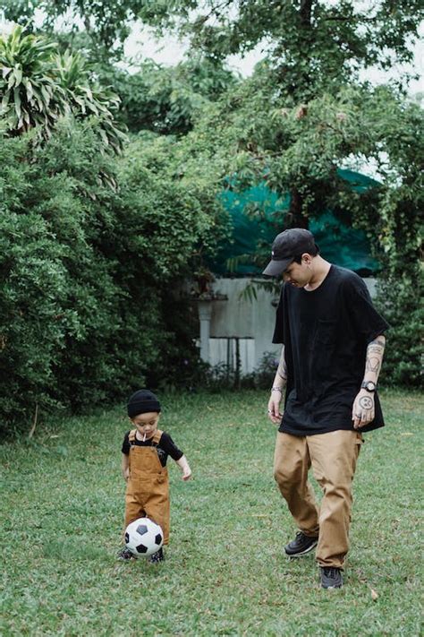 Father and Son Playing Football in the Backyard · Free Stock Photo