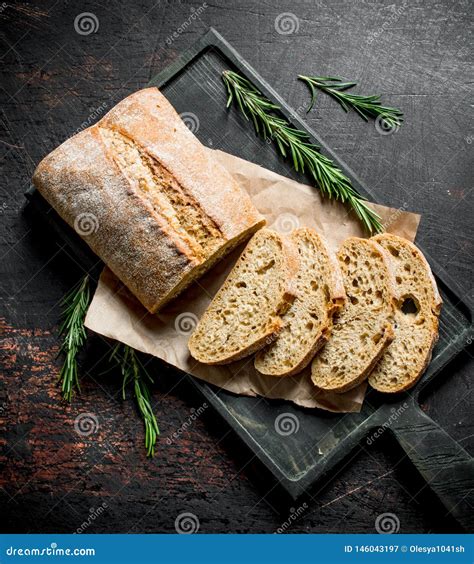 Sliced Ciabatta Bread On A Cutting Board With Rosemary Stock Image