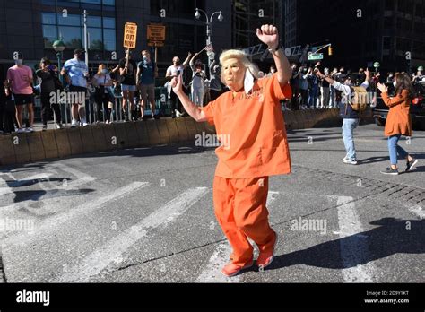 Reveler dancing in the street wearing a Trump mask in orange prison suit Stock Photo - Alamy