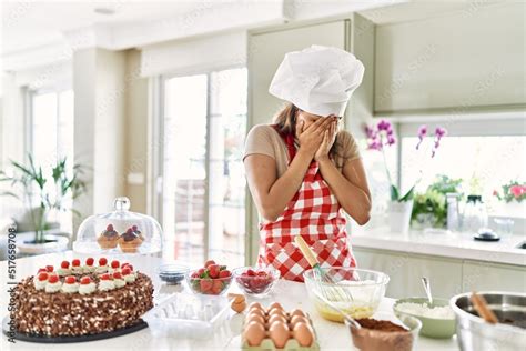 Beautiful Young Brunette Pastry Chef Woman Cooking Pastries At The Kitchen With Sad Expression