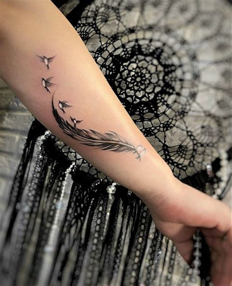 A Woman S Arm With A Feather Tattoo On It