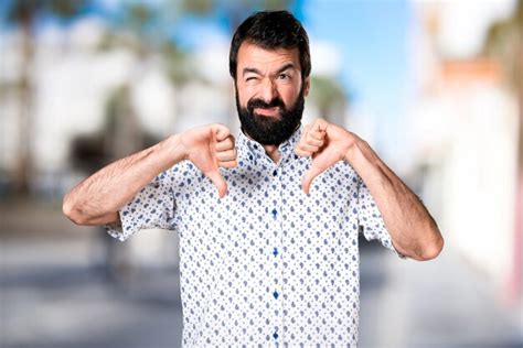 Premium Photo Handsome Brunette Man With Beard Making Bad Signal