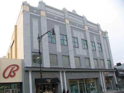 a building with many windows and people walking on the sidewalk