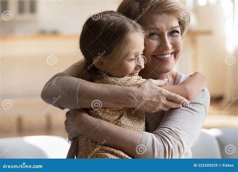 Happy Positive Elderly Granny Cuddling Small Granddaughter Stock Image