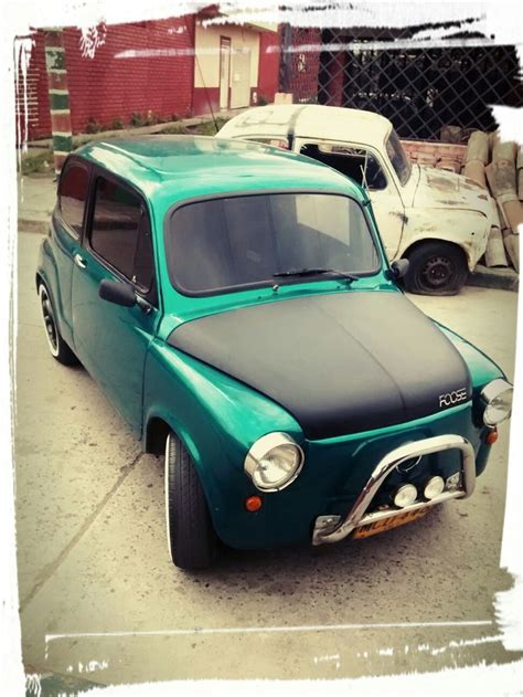 An Old Green Car Is Parked On The Street