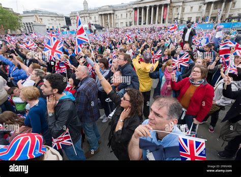 A Large Crowd Of People Gathered In Trafalgar Square To Watch A Giant