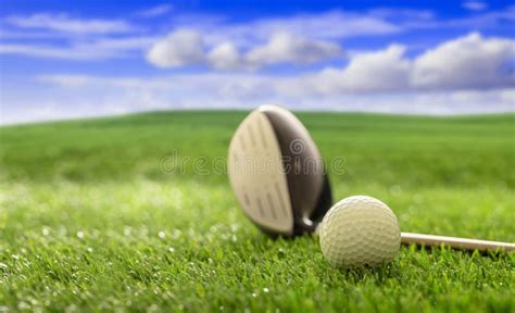 Golfball And Stick On Green Grass Golf Course Blue Cloudy Sky