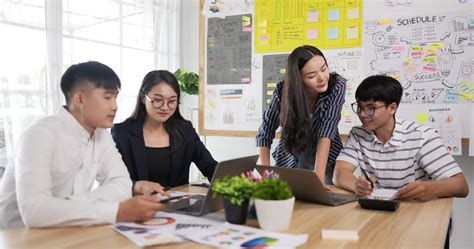 Asian woman and man team leader coach mentor talk to diverse employee