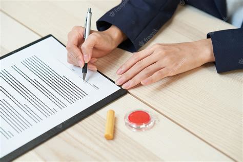 Mujer Firmando Documentos En El Escritorio Foto Premium