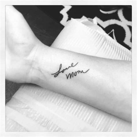 A Woman S Arm With The Word Love Mom Tattooed On Her Left Side Forearm