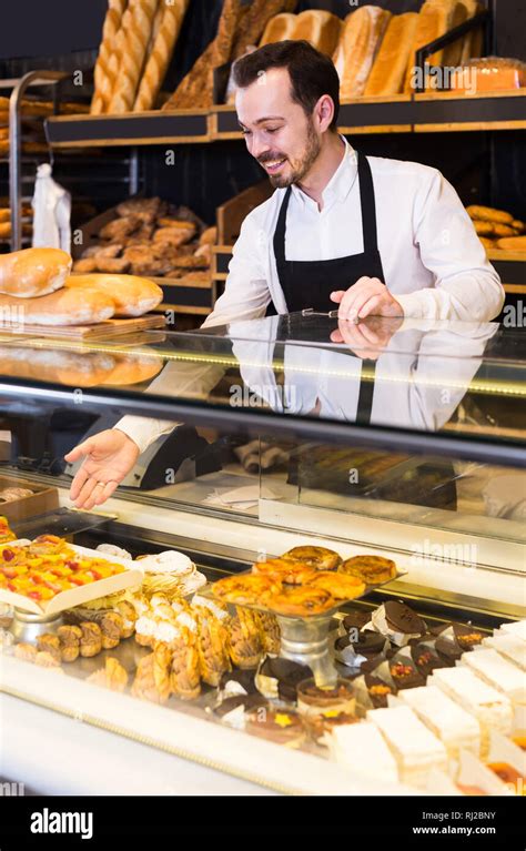 Smiling Italian Male Shop Assistant Demonstrating Fresh Delicious