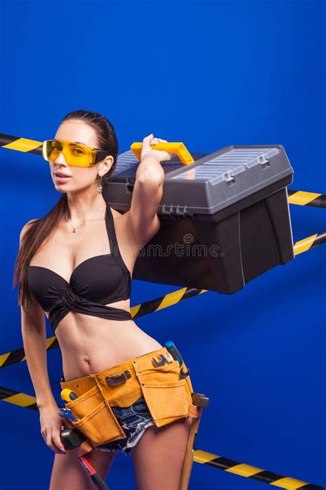 Brunette Builder On A Blue Background With An Electric Tool In The Hands Of Stock Photo Image