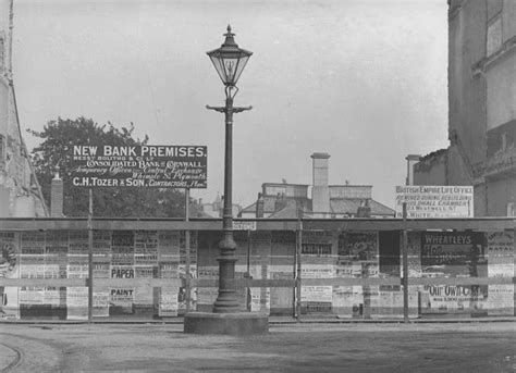 An Old Black And White Photo Of A Street Light In Front Of A Bank Building