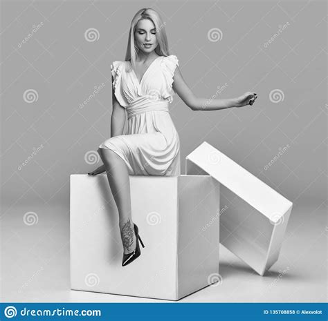 Gorgeous Sensual Blonde Woman In White Dress In A Big Shopping Box