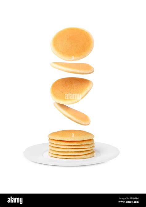 Many Fresh Pancakes Falling Onto Plate Against White Background Stock
