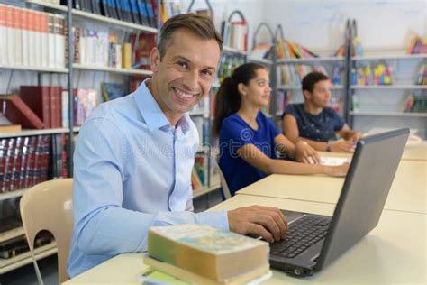 Three People Sat At Library Table Mature Man Using Laptop Stock Image