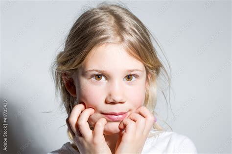 Portrait d une enfant fille blonde avec ses mains au visage 스톡 사진 Adobe Stock