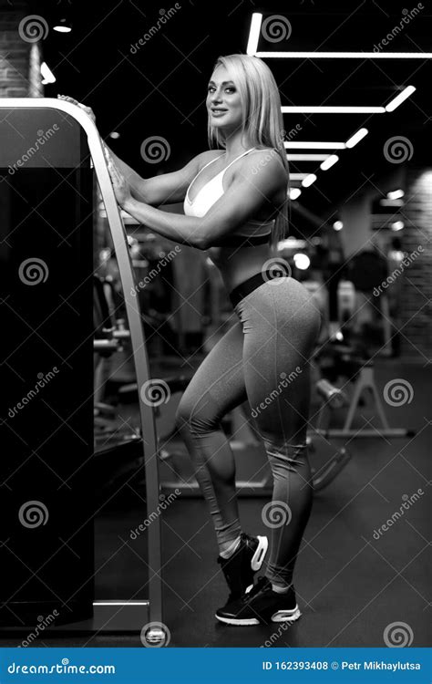 Beautiful Fitness Blonde Woman Is Standing Near Training Apparatus And