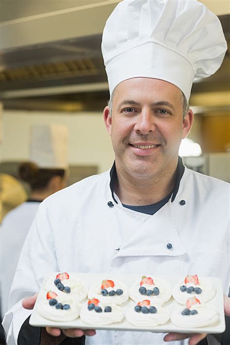 Happy Chef Presenting Plate Of Meringues