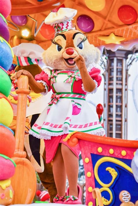 A Woman Dressed As A Clown Standing In Front Of Balloons