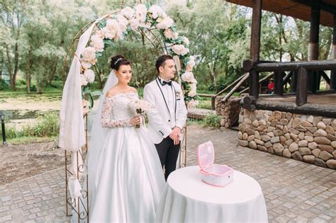 La Vista Lateral De Los Recienes Casados Felices Que Se Colocan Cerca