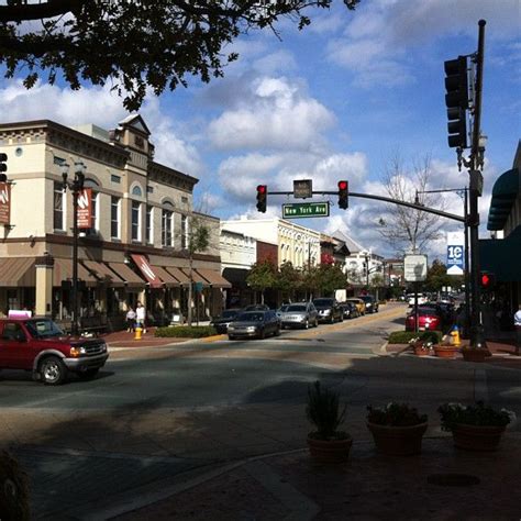 cars are driving down the street in front of shops and businesses on a ...