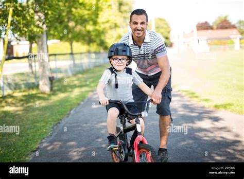 Father Teaching Son To Ride Bicycle Stock Photo Alamy